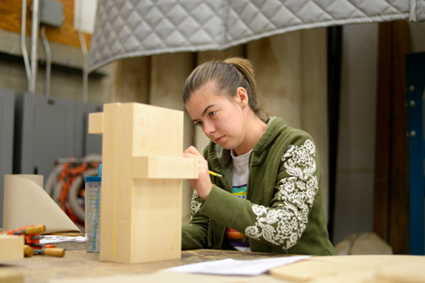 Woman sculpting wooden blocks