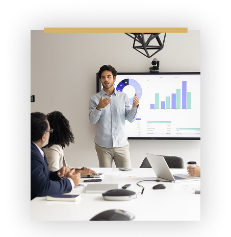 guy giving presentation in front of executives with graphs in the back